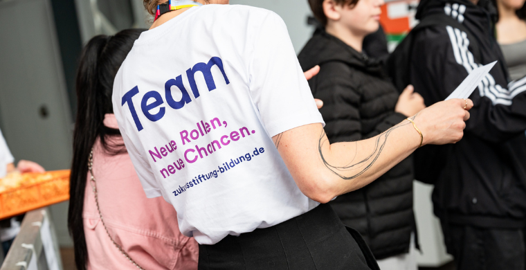 Eine Person trägt ein Team-T-Shirt.