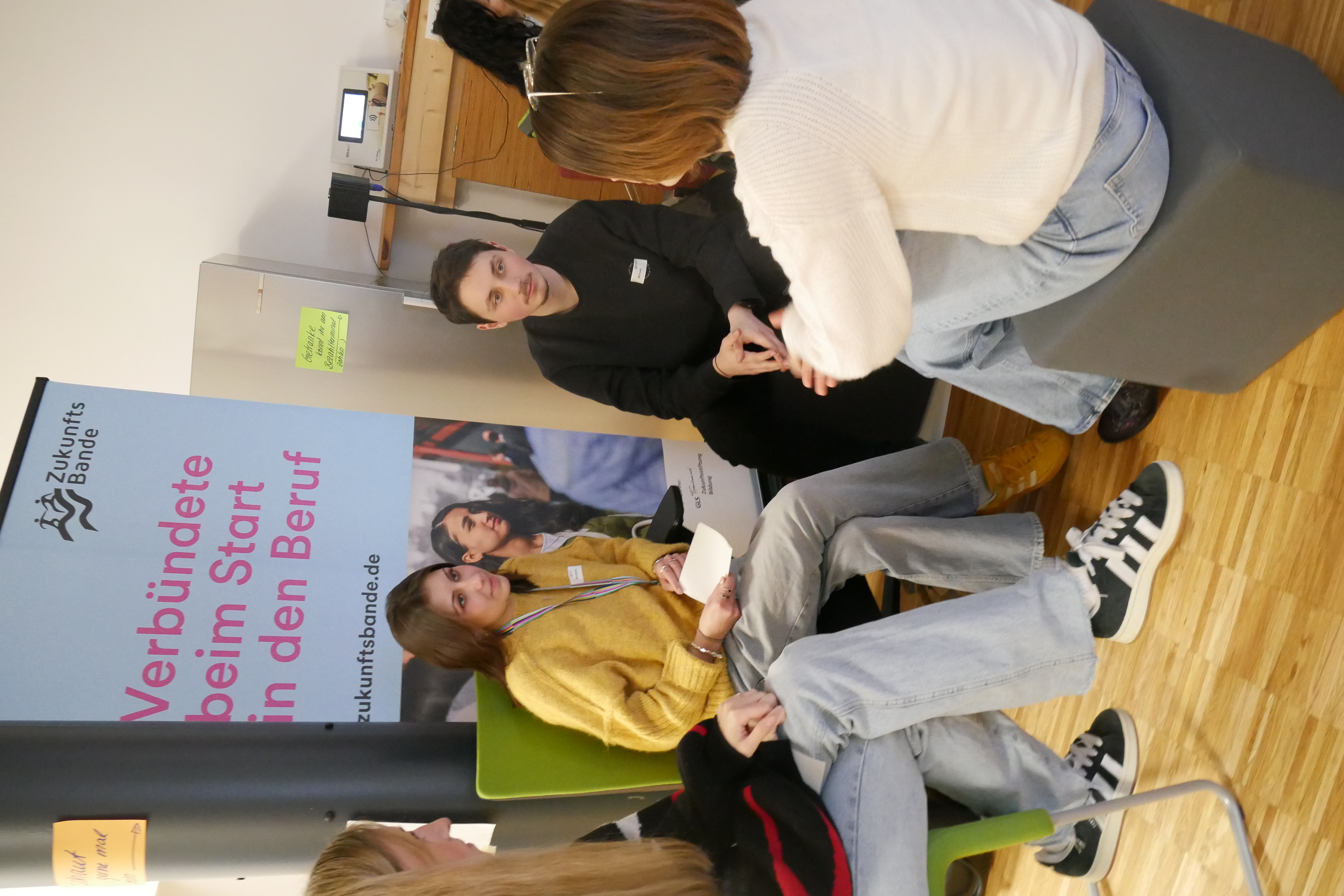 Junge Menschen sitzen bei einem Seminar zusammen und unterhalten sich.