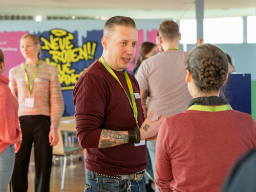 Lehrkräfte tauschen sich bei einer Fortbildung an einem Stehtisch aus.